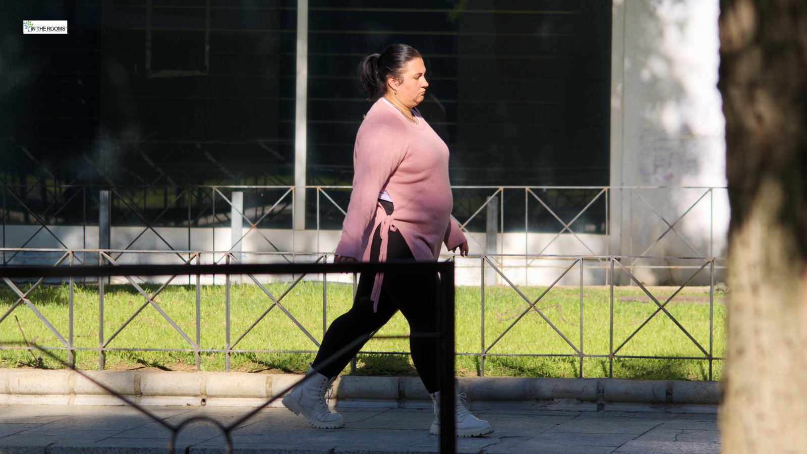 Woman walking outdoors on a sidewalk, representing walking in recovery as a grounding daily practice.