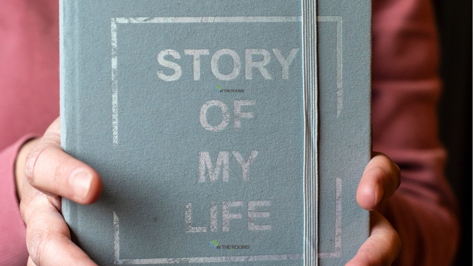 A person holds a journal labeled “Story of My Life,” symbolizing self-reflection, personal growth, and the understanding that past experiences do not define one's identity.
