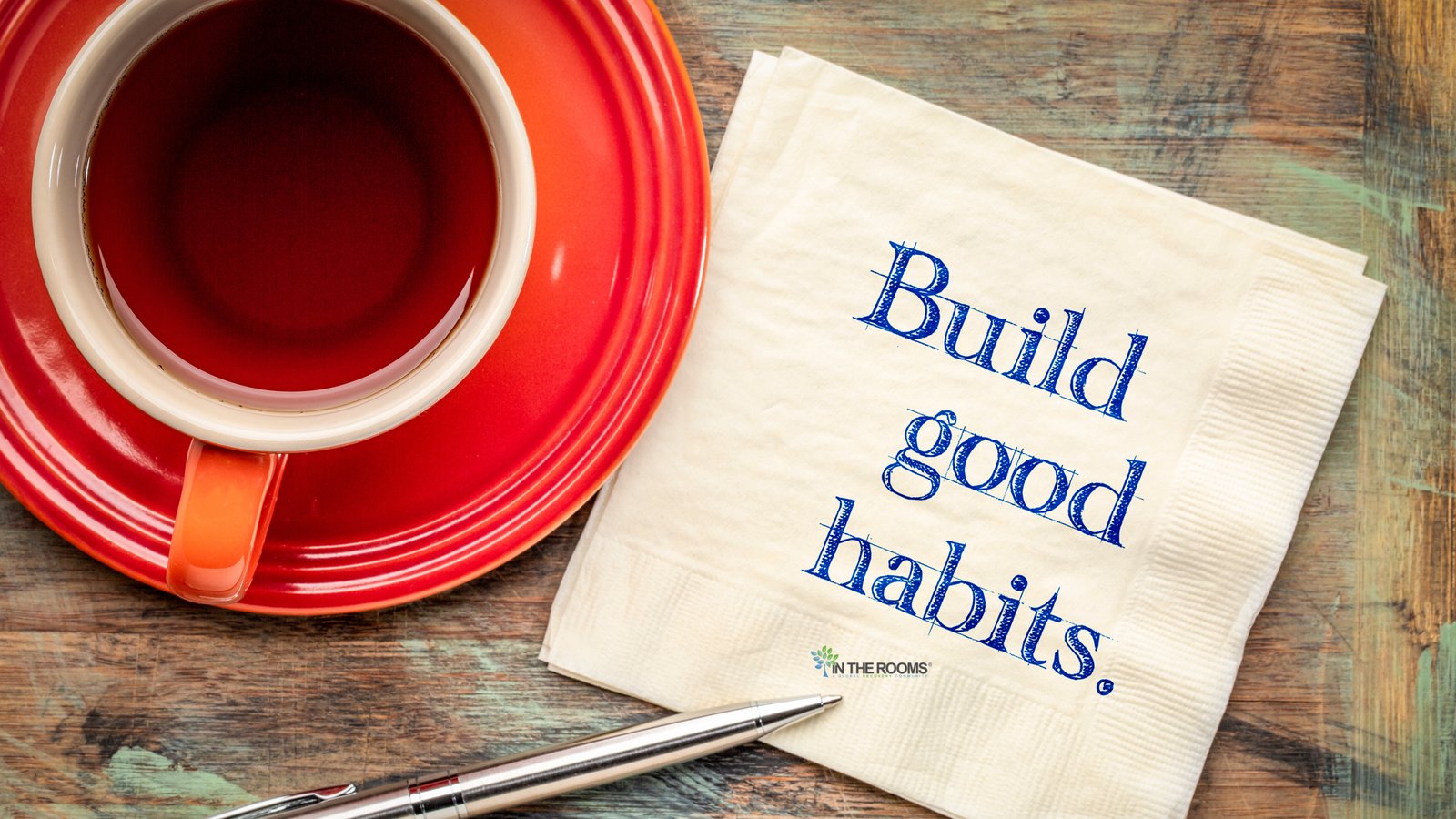A cup of tea beside a napkin with the words “Build good habits,” symbolizing small daily routines that support recovery.