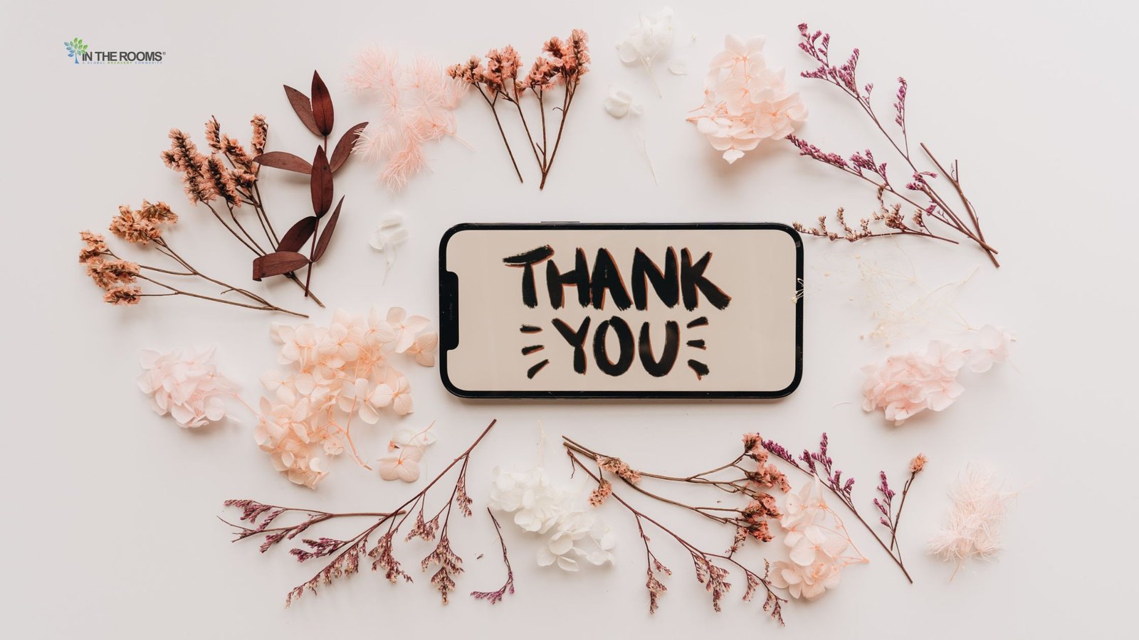 A smartphone displaying the words "Thank You" surrounded by dried flowers, symbolizing gratitude, hope, and positive change in recovery.